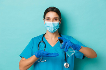 概念科维德检疫概念特写镜头美丽的女医生医疗面具手套实习医生风云手洗手液站蓝色的背景