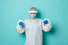 概念科维德流感大流行健康自信女医生个人保护设备指出手指复制空间显示标志站蓝色的背景