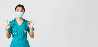 科维德冠状病毒疾病医疗保健工人概念兴奋深刻的印象亚洲女医生实习生医疗面具实习医生风云显示手势批准白色背景