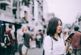 一边视图年轻的女人玩移动电话著名的背包客街考县三曼谷泰国