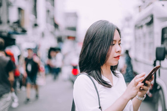 一边视图年轻的女人玩移动电话著名的背包客街考县三曼谷泰国