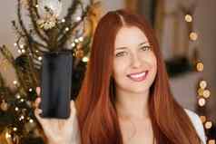 圣诞节电话调用假期问候概念快乐微笑女人显示屏幕移动智能手机圣诞节装饰背景