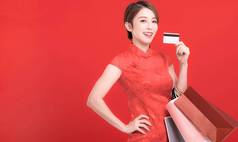 美丽的亚洲年轻的女人显示信贷卡持有购物袋