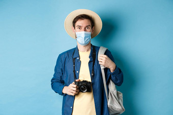 科维德旅行概念年轻的的家伙旅游<strong>医疗</strong>面具夏天他旅行在国外冠状病毒流感大流行采取<strong>图片</strong>假期蓝色的背景