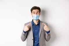 科维德流感大流行业务概念兴奋商人西装指出医疗面具相机白色背景