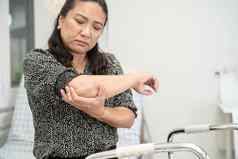 亚洲中年夫人女人病人触摸感觉疼痛肘手臂健康的医疗概念