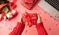女手持有红色的情人节礼物盒子前视图粉红色的背景