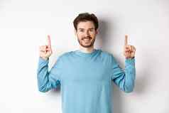图像年轻的现代的家伙胡子显示广告复制空间指出手指微笑检查手势白色背景