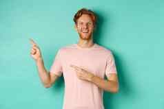 有吸引力的高加索人男人。t恤指出手指左微笑快乐显示广告站绿松石背景