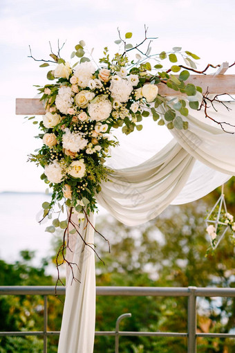 片段婚礼拱装饰茶玫瑰绿色叶子分支机构白色布