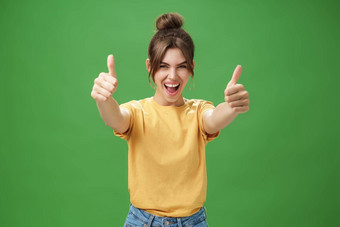 肖像快乐的热情的兴奋感情的美丽的欧洲女人黄色的t恤拉手拇指相机微笑广泛的支持喜欢的想法