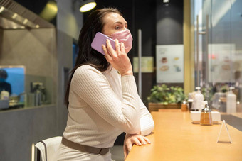 女人面具说话电话坐着咖啡馆