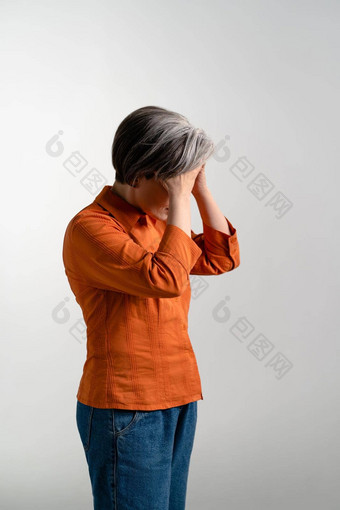 情绪低落的抑郁成熟的<strong>灰色</strong>头发的女人橙色衬衫持有额头手漂亮的中期岁的<strong>灰色</strong>头发的女人橙色衬衫孤立的<strong>灰色</strong>背景
