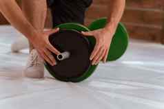 设置杠铃年轻的男人。弓膝盖添加黑色的绿色盘子设备重量培训概念体育设备培训重量损失健康的生活方式概念