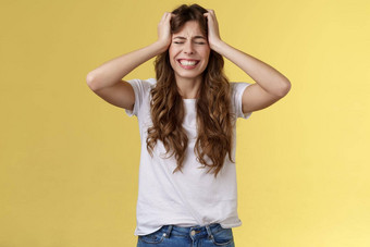 女孩感觉巨大的<strong>疼痛</strong>遭受令人心碎的分手抓住头恐慌关闭眼睛握紧<strong>牙齿</strong>焦急地陷入困境的感觉痛苦可怕的情况站黄色的背景绝望的悲伤