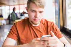 休闲技术沟通人概念关闭男人。智能手机发短信消息城市咖啡馆