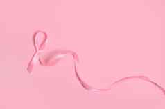 平躺长粉红色的缎丝带结束没完没了的乳房癌症意识医疗概念孤立的粉红色的背景复制空间10月意识月运动