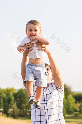 快乐年轻的父亲儿子玩有趣的夏天秋天场家庭孩子为父之道自然概念