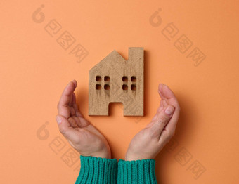 女手折叠木微型模型房子棕色（的）背景真正的房地产保险概念环境保护家庭幸福