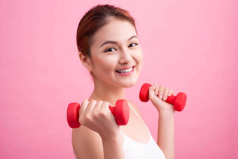 女人提升权重健身女人提升权重微笑快乐粉红色的背景