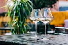木表格餐厅白色酒酒眼镜服务聚会，派对酒吧餐厅阳台阳光明媚的一天模糊背景植物生活场景