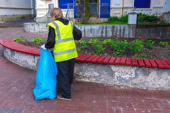 女人更清洁的收集垃圾环境卫生工人扫描街
