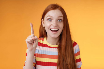 兴奋快乐快乐的年轻的红色头发的人女学生的想法回答提高指数手指尤里卡手势微笑激动宽眼睛计划<strong>优秀</strong>的建议橙色背景