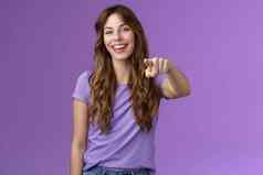 娱乐逗乐有吸引力的活泼的女孩卷曲的发型笑幸福的指出手指相机使选择微笑广泛的保证决定站紫色的背景