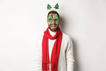 圣诞节一年庆祝活动概念英俊的有胡子的男人。惊讶穿聚会，派对眼镜附件白色背景