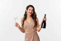 冬天假期庆祝活动概念美丽的女人享受圣诞节一年聚会，派对喝香槟眨眼相机站优雅的衣服
