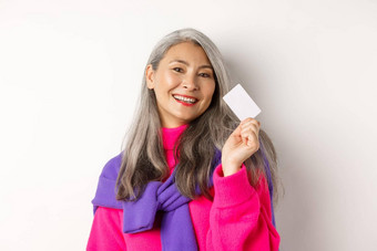 购物概念时尚的亚洲高级女人微笑显示塑料信贷卡支付非接触式站白色背景