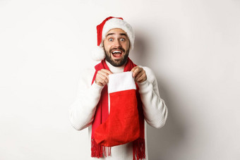 冬天假期庆祝活动概念惊讶有胡子的男人。内部圣诞节袜子接收一年礼物站白色背景