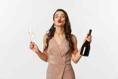 冬天假期庆祝活动概念美丽的愚蠢的女人优雅的衣服享受一年聚会，派对喝香槟皱纹嘴唇吻站白色背景