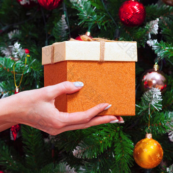 女手持有礼物盒子装饰圣诞节树