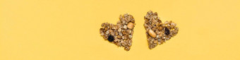 爱健康的食物格兰诺拉麦片使燕麦坚果葡萄干形式心黄色的背景前视<strong>图网</strong>络横幅