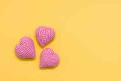 手工制作的情人节一天针织粉红色的心黄色的背景复制空间