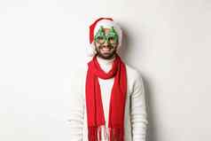 圣诞节一年庆祝活动概念快乐男人。笑穿圣诞老人他聚会，派对眼镜站白色背景