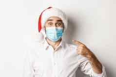 概念冠状病毒检疫冬天假期兴奋的家伙圣诞老人他指出脸面具站白色背景