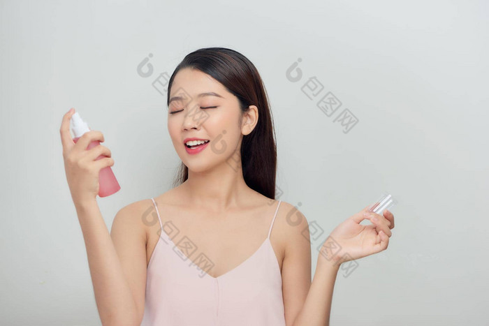 美丽的女人脸喷雾脸乳液美容白色背景隔离