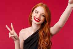 特写镜头肖像美丽的红色头发的人欧洲女人庆祝生日享受聚会，派对采取自拍和平标志喜气洋洋的满意微笑有趣的红色的背景