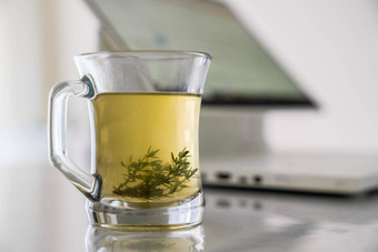 玻璃透明的杯Herbal茶草叶子背景工作电脑概念放松