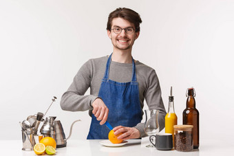 咖啡师咖啡馆工人酒保概念肖像快乐年轻的男人。开始职业生涯使咖啡切片橙子微笑相机准备货物开放问候客户