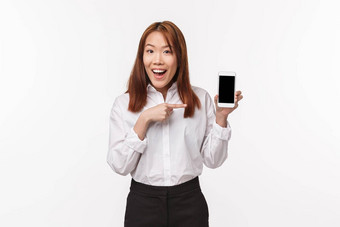 肖像快乐优雅的年轻的漂亮的亚洲女人白色衬衫<strong>介绍</strong>应用程序做<strong>广告公司</strong>网站程序指出手指移动电话白色背景