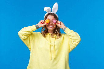 假期传统庆祝活动概念快乐无忧无虑的微笑高加索人女人庆祝复活节持有画鸡蛋<strong>眼睛</strong>咧着嘴笑穿可爱的<strong>兔子</strong>耳朵蓝色的背景