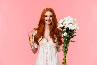 有吸引力的兴奋浪漫的红色头发的人女朋友收到礼物持有白色<strong>花</strong>束<strong>花</strong>玻璃<strong>香槟</strong>喝庆祝场合完美的情人节日期粉红色的背景