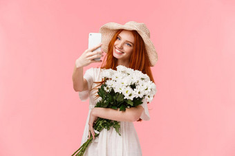 浪漫的时刻社会媒体技术概念迷人的诱人的红色头发的人女衣服稻草他采取自拍智能<strong>手机应用应用</strong>程序过滤器持有花束花