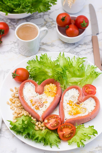爱早餐炸鸡蛋心形状的香肠生菜樱桃西红柿板杯咖啡垂直视图