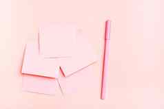概念粉红色的空白广场小表纸笔粉红色的背景前视图
