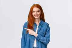 快乐的红色头发的人女人牛仔布衬衫指出手指左复制空间微笑推荐好产品审查服务指示网站站白色背景