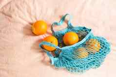 新鲜的橙子网袋织物背景浪费硬光